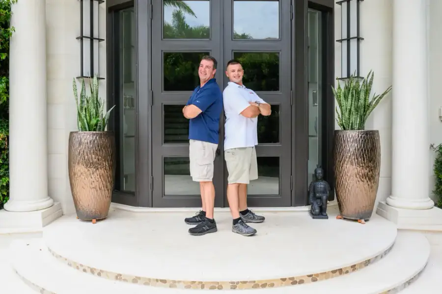 Two members of the Creative Images Painting team in branded polo shirts at a client's entry door in Boca Raton